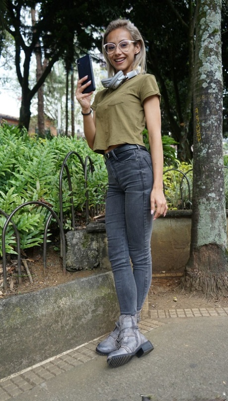 Verónica Leal posando sobre su capucha con camiseta verde y jeans ajustados