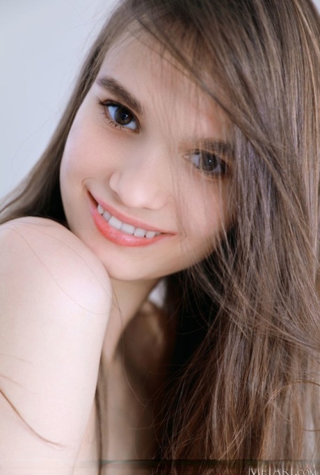 La dulce joven anastasia bella se desnuda sobre una mesa con calcetines blancos