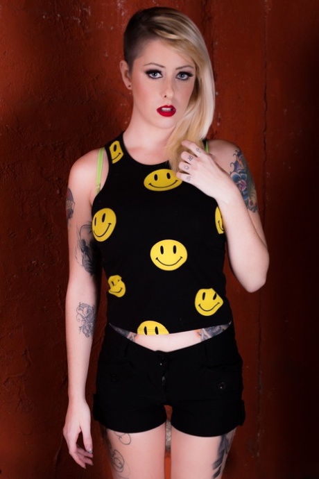 La rubia tatuada nicole malicia se desnuda con botas OTK mientras usa labios rojos